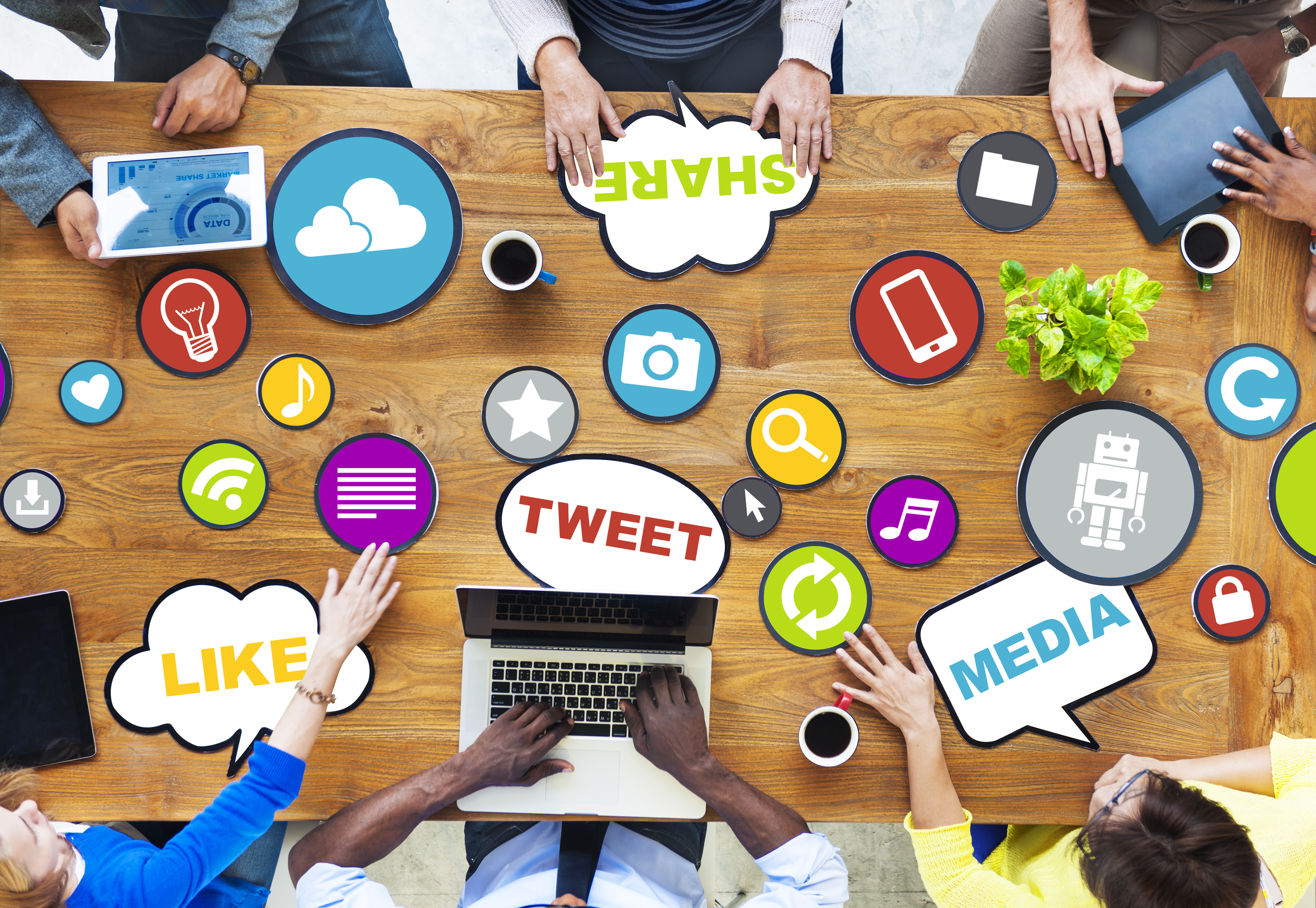 Group of people around a table using social media.